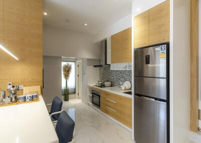 Modern kitchen with wooden cabinets, stainless steel appliances, and a white countertop