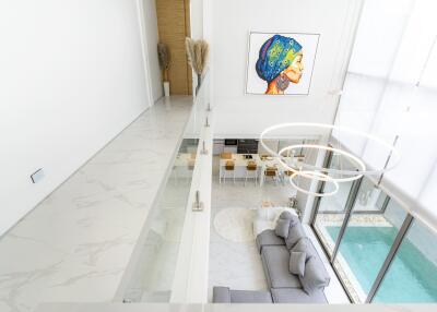 Modern living room with pool view, white walls, and large artwork