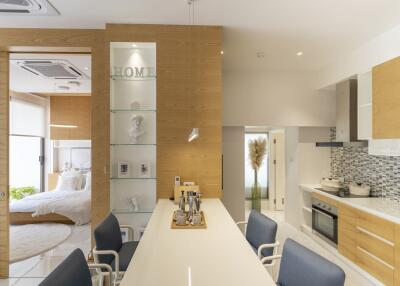 Modern open-plan kitchen with dining area and view into the bedroom