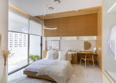 Modern bedroom with bed, desk, large window and wooden accents