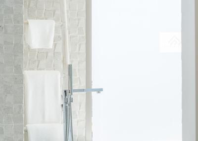 Modern bathroom with a white bathtub and green plant