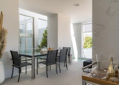 Modern dining area with glass table and four black chairs