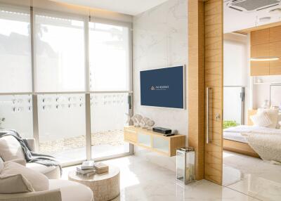 Modern living room connected to bedroom with large glass doors and natural light