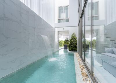 Modern outdoor pool area with waterfall feature