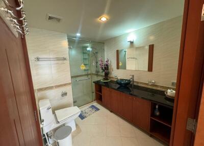 Modern bathroom with glass shower, toilet, and vanity area with a sink