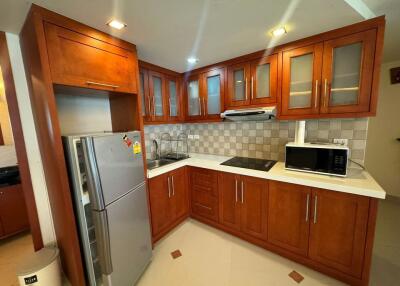 Modern kitchen with wooden cabinets, appliances, and tile backsplash