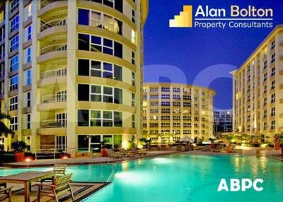 Exterior view of residential buildings with pool area at night