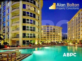 Exterior view of residential buildings with pool area at night