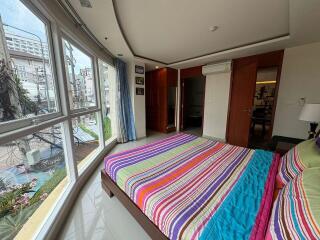 Bright bedroom with large window and colorful bedding