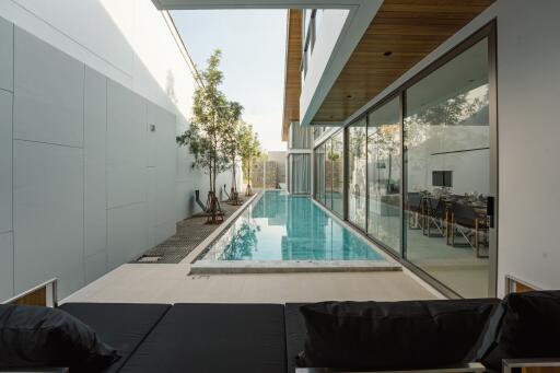 Modern house with poolside view and outdoor seating area