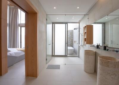 Modern bathroom with dual sinks, large mirror, and a bathtub area.