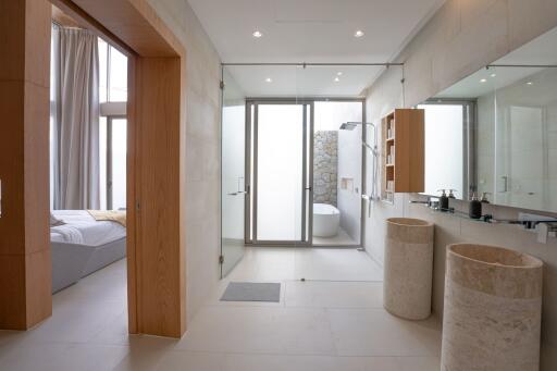 Modern bathroom with dual sinks, large mirror, and a bathtub area.