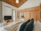 Spacious bedroom with wooden ceiling, large wardrobe, and modern amenities