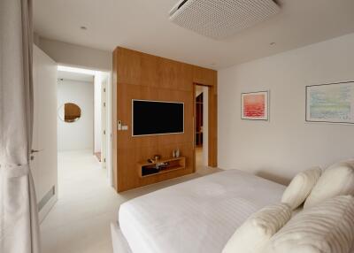 Modern bedroom with a wall-mounted TV and wooden decor