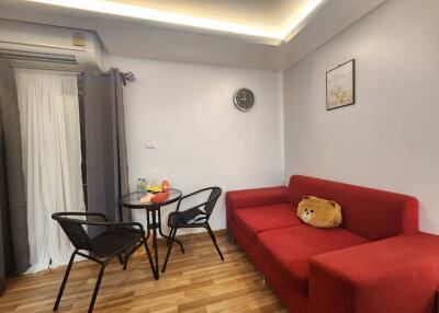 Living room with red sofa and small dining area