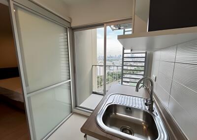 Modern kitchen with stainless steel sink and access to a balcony with city view