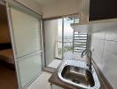 Modern kitchen with stainless steel sink and access to a balcony with city view