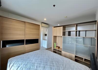 A modern bedroom with wooden furniture and a neatly made bed