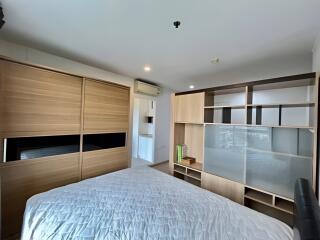 A modern bedroom with wooden furniture and a neatly made bed