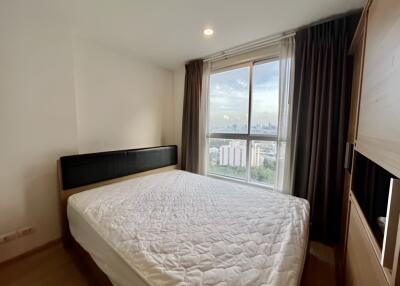 A bright bedroom with a large window and a double bed