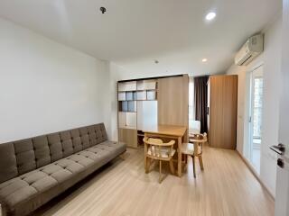 Cozy living area with wooden flooring, modern furniture, and natural lighting