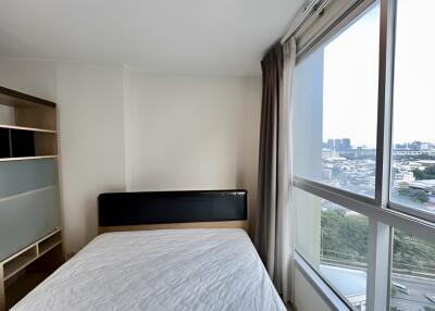 Bright bedroom with large window and city view