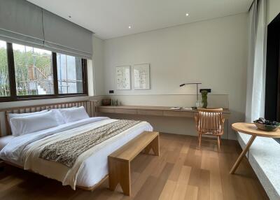 Modern bedroom with large windows and wooden flooring