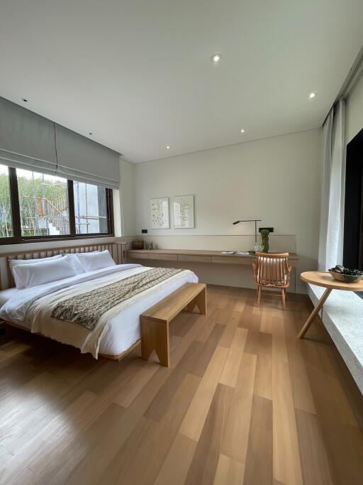 Modern bedroom with large windows and wooden flooring