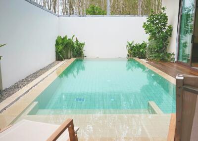 Swimming pool with wooden deck and lounge chairs