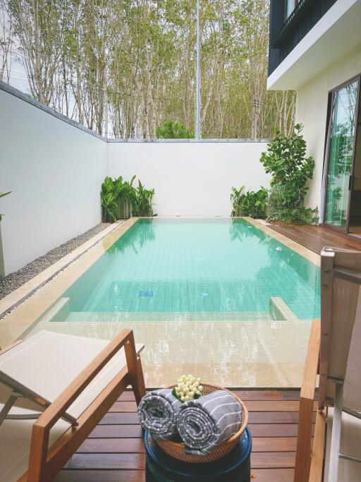 Swimming pool with wooden deck and lounge chairs