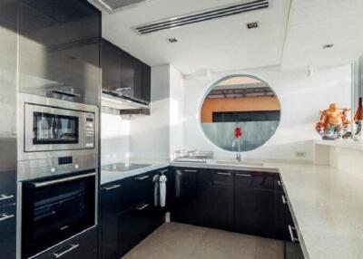 Modern kitchen with built-in appliances and circular window