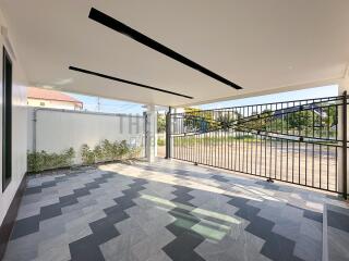 Covered parking area with modern tiling and gated entrance