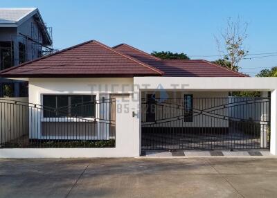 Front view of a modern one-story house with a gated driveway