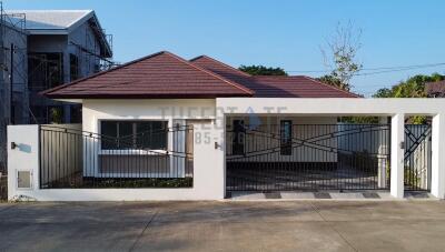 Front view of a modern one-story house with a gated driveway