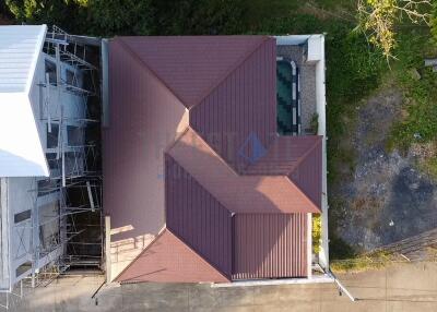 Aerial view of residential building showing the roof and surrounding area