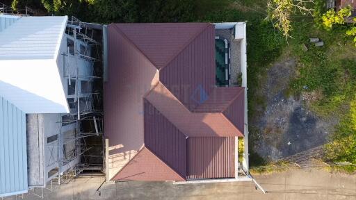 Aerial view of residential building showing the roof and surrounding area