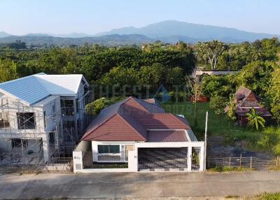 Aerial view of a house with a spacious garden and surrounding greenery