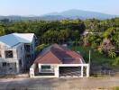 Aerial view of a house with a spacious garden and surrounding greenery