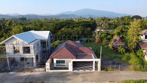 Aerial view of a house with a spacious garden and surrounding greenery