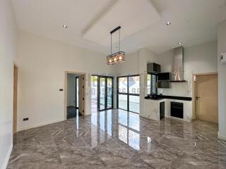 Modern kitchen and living area with marble flooring and large windows