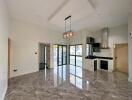 Modern kitchen and living area with marble flooring and large windows