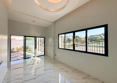 Spacious living area with large windows and modern flooring