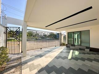 Modern building entrance with large sliding glass doors and spacious driveway