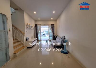 Living room with a staircase, furniture, and large windows