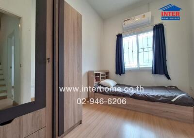 Bedroom with wooden flooring, window, air conditioning, wardrobe, and bed