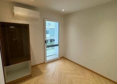 Modern bedroom with wooden flooring and large window