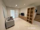 Modern living room with wooden flooring, TV unit, and ample lighting