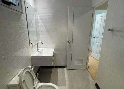 Modern bathroom with a sink, toilet, and window