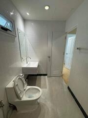 Modern bathroom with a sink, toilet, and window