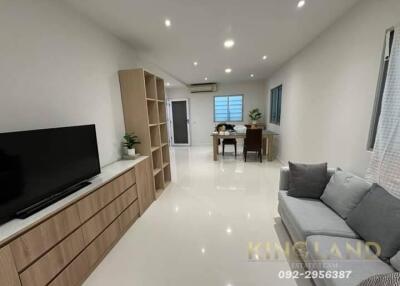 Modern living room with TV, sofa, and dining area